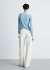 Sweater gris de punto canalé con cuello barco y mangas largas.