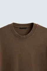 Camiseta azul marino de corte holgado, confeccionada en algodón con cuello redondo y mangas cortas. Presenta un efecto de lavado que le da una apariencia única.