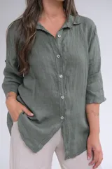 Camisa verde militar de lino italiano, de corte holgado, con cuello clásico, cierre frontal con botones y mangas 3/4 con botón para ajustar el largo.