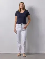 Pantalón de jean blanco, de corte recto, tiro alto, pretina con pasadores, botón y cierre. Con bolsillos delanteros y traseros.