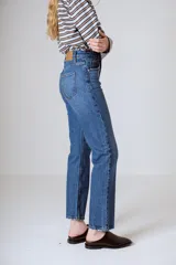 Jean de tiro alto y pierna recta, color azul medio. Confeccionado en 98% algodón y 2% elastano, con diseño clásico de cinco bolsillos.