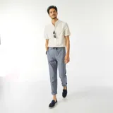 Camisa blanca de manga corta con cuello clásico y estampado de hojas.