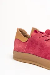 Zapatillas acordonadas de cuero vacuno color borgoña con detalle de gamuza en el talón y suela de goma color caramelo.