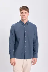 Camisa de lino azul oscuro de corte clásico, con cuello abotonado y bolsillo en el pecho.