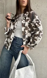 Sobrecamisa de manga larga con estampado de vaca en tonos marrón, blanco y negro.
