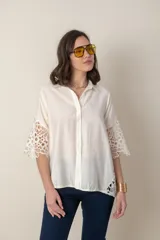 Camisa blanca lisa con aplique de guipiur en costados y mangas, de calce holgado.