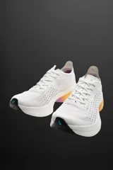 Zapatilla deportiva para correr largas distancias, color gris y negro, con parte superior de tejido de punto transpirable y suela de TPE-A. Cuenta con placa de carbono interna, plantilla interior OrthoLite®, stack de 39 mm y drop de 8 mm. Marca Zara Athleticz.