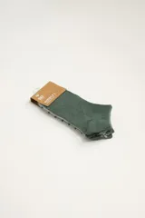 Pack de tres pares de medias soquete de algodón. Un par es de color verde liso, otro par es gris con talón y puntera verde, y el tercer par es gris a rayas horizontales verdes.