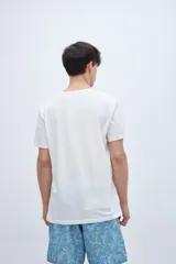 Remera de manga corta color lila con cuello redondo y parche con texto en el pecho.
