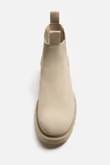 Bota Chelsea color beige de cuero, con elásticos laterales, tiradores delanteros y traseros, y suela track.