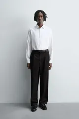 Camisa blanca de manga larga, corte slim fit, con cuello italiano y cierre frontal de botonadura.