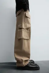 Pantalón cargo color beige, de corte relaxed fit, con bolsillos frontales, traseros con solapa y bolsillos laterales tipo parche con solapa.