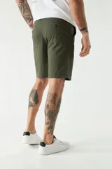 Bermuda color beige, de corte chino clásico, con bolsillos laterales y traseros, cierre con botón y cremallera, presillas para cinturón y logo bordado. Confeccionada en algodón y spandex.