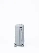 Valija rígida color gris con ruedas giratorias, manija extensible y candado de seguridad.