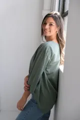 Blusa verde militar de corte holgado, con escote en V, mangas 3/4 y detalle de bordado calado con forma de paisley en el frente.