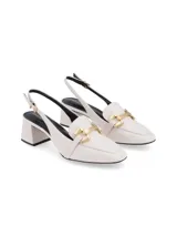 Zapato mule negro de cuero napa con punta cuadrada, taco cuadrado forrado y ornamento metálico dorado.