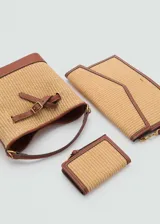 Billetera pequeña color beige con textura de rafia y borde de cuero marrón. Tiene cierre metálico a presión, logo en relieve, seis ranuras para tarjetas y cierre de cremallera.