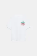 Camiseta blanca de algodón con cuello redondo y estampado frontal con el logo de la cevichería "La Islilla" en verde y rojo.