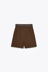 Bermuda color marrón chocolate de tiro alto con pinzas delanteras y cinturón trenzado. Bolsillos frontales. Cierre delantero con cremallera, botón interior y gancho.