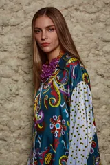 Camisa holgada estampada con motivos paisley en tonos marrón, beige y azul. Tiene cuello solapa, mangas largas y cierre frontal con botones.