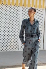 Pantalón culotte de tiro alto con trabillas, bolsillos laterales y traseros. Detalle de bordados combinados a contraste. Cierre frontal con cremallera y botón.
