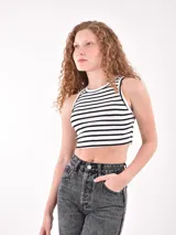 Musculosa corta a rayas horizontales blancas y negras, con cuello redondo y sisas con ribete negro.