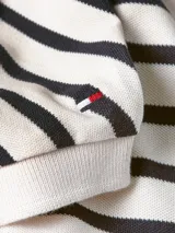 Chomba de corte amplio con diseño de rayas horizontales en blanco y azul marino. Tiene cuello en V y mangas cortas.
