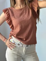 Blusa color terracota con textura arrugada y mangas cortas con volantes.
