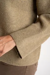 Sweater de punto color tostado con calce oversize, cuello redondo y mangas largas anchas. Presenta terminaciones acanaladas en cuello, puños y ruedo.
