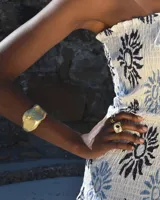 Brazalete rígido plateado con textura irregular.