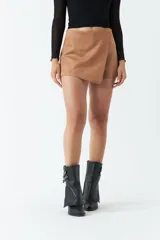 Short falda color marrón de gamuza con corte asimétrico y cierre invisible lateral.