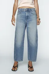 Pantalón de jean celeste de corte amplio, con tiro medio, cinco bolsillos y costuras torcidas.