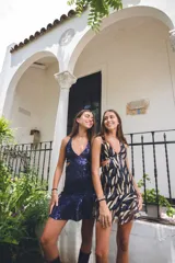 Vestido corto de lentejuelas color verde oliva, con escote en V, breteles finos cruzados en la espalda, cut-outs laterales y volado en el ruedo.