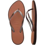 Ojotas Havaianas Slim Point color crema con contorno verde oscuro y logo en las tiras.