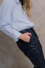 Pantalón de tiro medio con fit flare, color negro engomado.