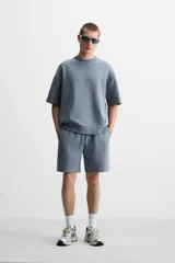Sudadera negra de corte relaxed fit, confeccionada en tejido interlock de algodón con elasticidad. Tiene cuello redondo, manga corta y bajo acabado en rib.