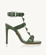 Sandalias de tacón alto color verde oliva, con punta cuadrada, tiras con tachas piramidales y pulsera al tobillo con hebilla.