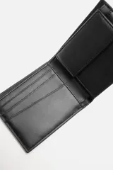 Billetera tipo cartera de corte liso color verde militar. Cuenta con un compartimento para billetes, tres compartimentos para tarjetas y un monedero con cierre mediante clip.
