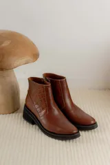 Bota corta color marrón con textura símil cuero de cocodrilo, caña baja, punta redondeada y taco cuadrado.