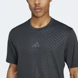 Remera de entrenamiento Adidas de manga corta y cuello redondo, color negro, con un patrón texturizado de espiga en relieve tono sobre tono. Presenta un corte ajustado (slim fit) y el logo de Adidas en el pecho.