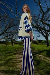 Camisa holgada con estampado de rombos azules y blancos, cuello solapa, manga corta y abotonada. Talle único, similar a un M.