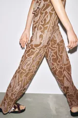 Pantalón marrón de tiro alto confeccionado en tejido efecto ante con aplicación de crochet a contraste.