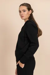Chaqueta deportiva negra con cierre frontal, capucha con cordones ajustables y bolsillos laterales.