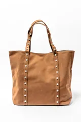Bolso tipo shopper color negro con apliques de tachas plateadas en los bordes y las asas.