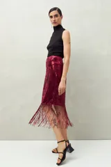 Falda larga de lentejuelas color borgoña con terminación en flecos.