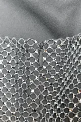 Vestido corto plateado de tejido tipo red con aplicación de strass, escote recto y hombros descubiertos.