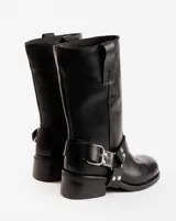 Bota de cuero marrón oscuro con caña media, estribo desmontable y hebilla metálica. Taco de madera de 5cm y suela de caucho.