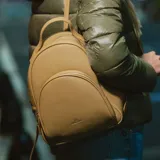 Mochila pequeña de cuero sintético color amarillo, con doble compartimento con cierre, asa de mano y correas regulables.
