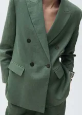 Blazer verde musgo de lino, con solapas de muesca, cierre cruzado con doble botonadura, mangas largas con puños abotonados, diseño recto, forro interior y dos bolsillos de solapa frontales.