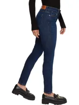 Jeans de calce ajustado color azul oscuro, con diseño de cinco bolsillos, cierre de botón y cremallera, detalles distintivos de Tommy Hilfiger, logo sobre el bolsillo posterior y parche en la cintura.